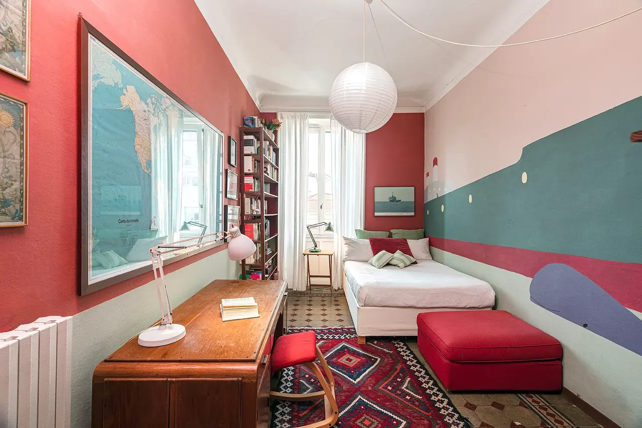 Salotto con poltrone e libreria dopo un intervento di restyling